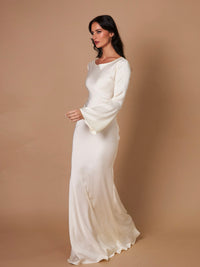 Robe longue ivoire près du corps, manches longues, encolure ronde, coupe fluide.