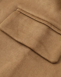 Beige jacka i mockaimitation med synlig bröstficka och paspoal på slån.