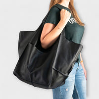 Sac de voyage surdimensionné en cuir noir, anses longues et empiècement gris
