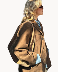 Brun blazer i mockaimitation från sidan med lockficka och knäppning.