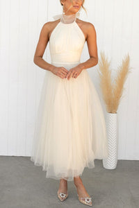 Robe chic en tulle blanc cassé, col montant, sans manches, jupe évasée mi-longue.