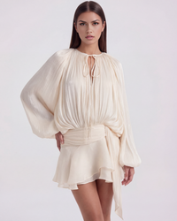 Robe ivoire courte à manches bouffantes, encolure nouée, ceinture et jupe volante