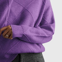 Pull col roulé violet à motif géométrique, gros plan sur le poignet et la maille.