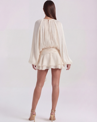 Robe ivoire vue de dos : encolure dos, manches longues bouffantes, jupe volantée