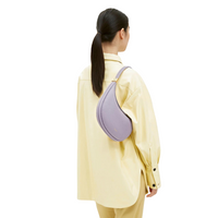 Sac croissant lavande porté de dos, forme demi-lune et fermoir doré