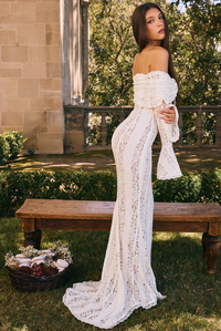 Robe longue en dentelle blanche, épaules nues, laçage au buste et festons aux manches