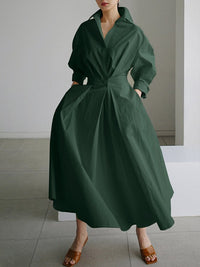 Robe longue vert foncé à col V, ceinture nouée, manches bouffantes, jupe évasée