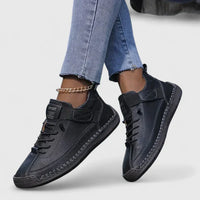 Baskets orthopédiques noires à lacets, semelle crantée et sangle velcro.