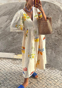 Robe longue blanche à fleurs jaunes et bleues, manches bouffantes, taille froncée