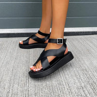 Sandales orthopédiques noires à deux brides, boucle à la cheville et semelle épaisse.