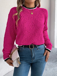 Pull rose fuchsia en maille texturée, encolure ronde côtelée, bouton doré, poignets rayés