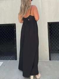 Combinaison noire à col V, bretelles fines et pantalon ample longueur maxi.