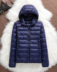 Veste imperméable à capuche matelassée bleu marine, zip central.