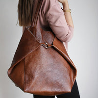 Grand sac cabas rétro marron avec pochette zippée et fermeture à anneau sur le devant.