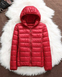 Veste imperméable à capuche matelassée rouge, fermeture zippée centrale.