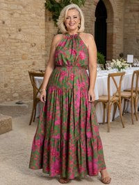 Robe midi sans manches motif floral rose et vert, encolure haute drapée, jupe évasée.