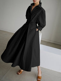 Robe longue noire col V, manches bouffantes, ceinture nouée, jupe ample évasée