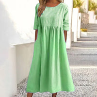 Robe midi verte en lin-coton, encolure ronde, manches courtes, taille froncée.