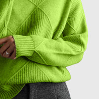Pull col roulé vert à motif géométrique, gros plan sur la manche et le motif croisé.