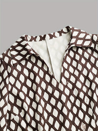 Détail robe imprimée : encolure en V et tissu à motifs en grille.