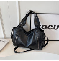 Sac cabas en cuir noir, anses doubles et bandoulière, poches zippées sur l’avant