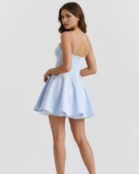 Robe courte bleu ciel à bretelles fines, vue de dos, jupe évasée plissée.