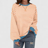 Pull ample rayé orange et blanc, encolure ronde, manches longues, poignets froncés