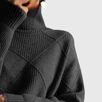 Col roulé en maille noire à motif géométrique croisé, manches longues côtelées