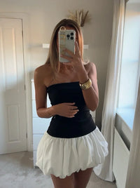 Robe courte noir bustier et jupe blanche à ourlet ballon, taille cintrée