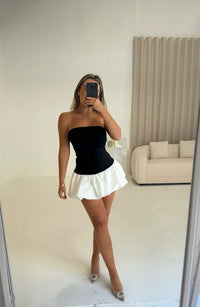 Robe courte noir bustier et jupe blanche à volants, silhouette évasée