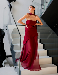 Robe longue bustier bordeaux, taille cintrée, bas volanté avec drapé et fente.