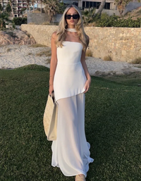 Robe longue bustier blanche, bretelles fines, jupe ample avec superposition asymétrique.