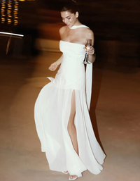 Robe longue bustier blanche, taille cintrée, jupe en voile avec fente et volants.