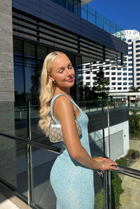 Robe longue sans manches bleu clair à paillettes, effet brillant, silhouette près du corps.