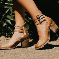 Bottines marron à talon moyen, bride à boucle sur le dessus, fermeture à l’arrière.