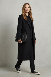 Manteau long noir à motif chevrons, col tailleur, fente et boutons visibles