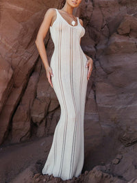 Robe longue blanche en maille, bretelles fines, motifs ajourés et coutures verticales.