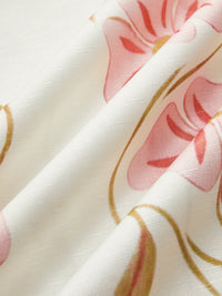 Détail tissu blanc de robe avec imprimé floral rose, lignes courbes et formes.