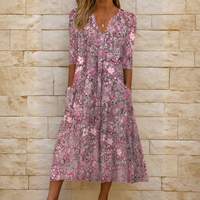 Robe fluide à col V rose à motifs floraux, boutonnage, manches trois-quarts.