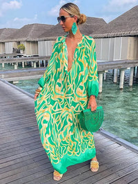 Robe longue à col en V verte à motif abstrait, manches longues et fente.