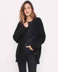 Gilet cocon noir en maille, col V boutonné, coupe ample et manches longues, poches plaquées.