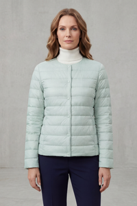 Veste matelassée légère bleu clair à boutons, fermeture centrale, manches longues, coutures horizontales.