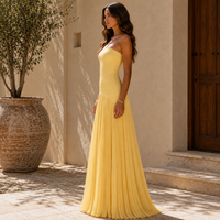 Robe longue jaune, buste bandeau ajusté et jupe plissée, vue de profil.