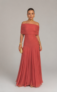 Robe longue asymétrique brique, épaules dénudées, manches courtes évasées, taille ajustée.
