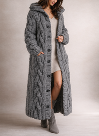 Manteau long en maille torsadée gris foncé, capuche et boutons devant.