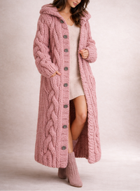 Manteau long en maille torsadée rose, capuche et rangée de boutons devant.