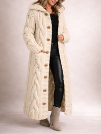 Manteau long en maille torsadée beige, capuche et boutons sur l’avant.