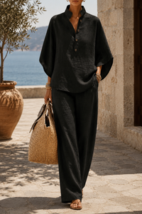 Ensemble tunique boutonnée et pantalon ample en lin noir, emmanchures larges.