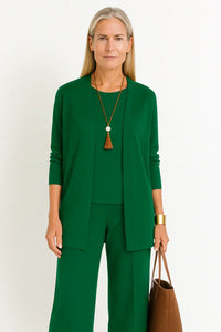 Ensemble trois pièces vert : veste ouverte, haut coordonné et pantalon large assorti.