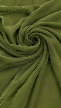 Tissu vert de robe fluide, texture froissée et drapée en spirale.